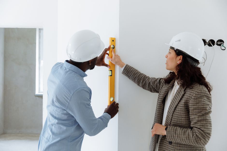 Friendly construction contractor reviewing plans with a homeowner